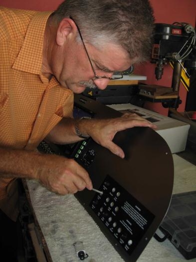 Filing out holes to take circuit breakers.