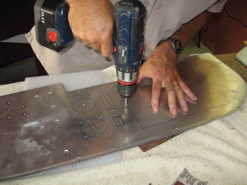 Deburring holes through panel.