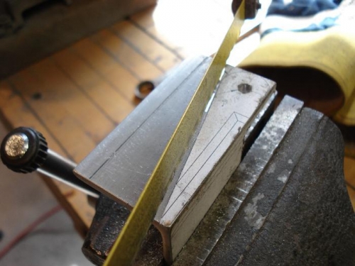 Cutting aluminum angle stock.