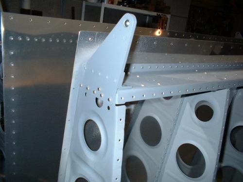 Outboard aileron bracket riveted to spar