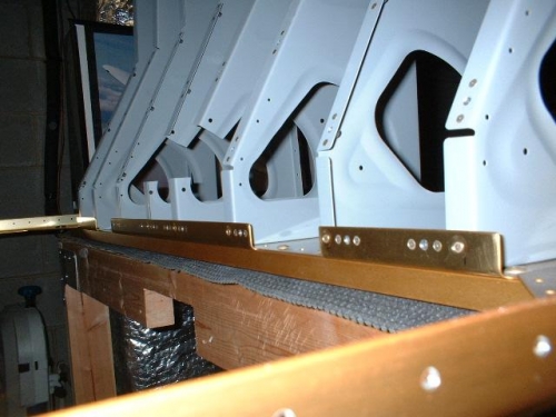 Top flanges of ribs riveted to forward center section bulkhead