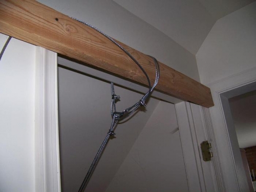 Steel cable anchored above the door frame at the top of the stairs