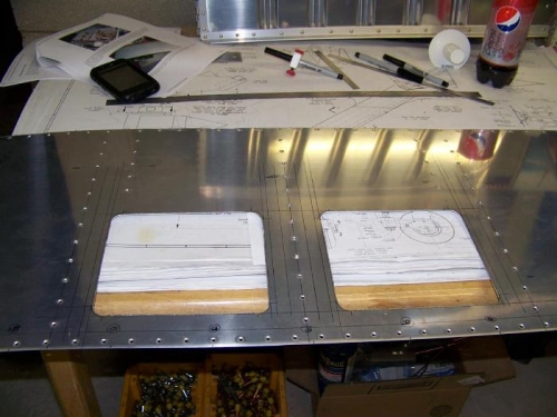 Two roughly cut out access panels in the top forward skin