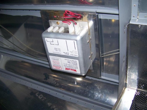 Whelen power supply secured on left side, aft of the baggage area
