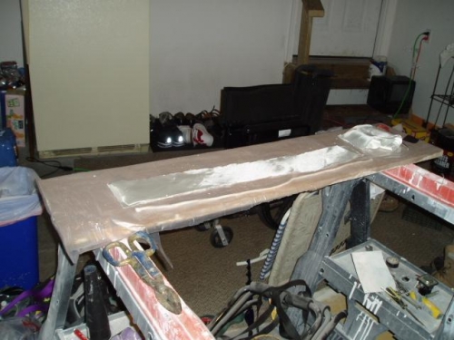 Fiberglass cloth cut approximately to size and laying on plastic