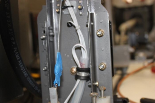 Center tunnel conduit comes into the flap housing area and is clamped. ELT wire goes back down.