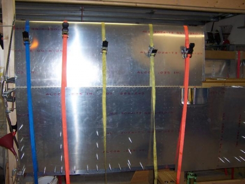 The working portion of the straps disappear inside the bottom skin where they go underneath the spar.