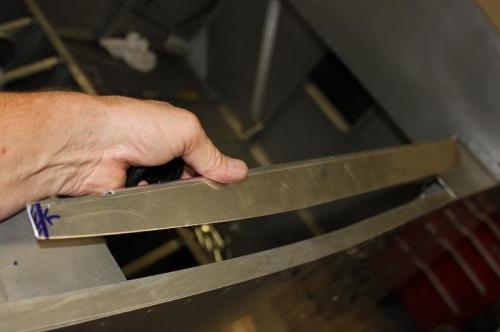 Cut and trimmed to follow the shape of the fuselage side.