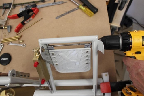 Drill the two mounting holes plus the attaching angles for one long bolt.