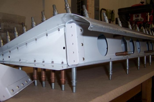 Flap attach bracket partially riveted.  The side pieces go on after riveting on the end rib.
