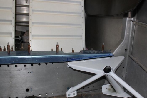 Positioned gear weldment to allow trimming of forward seat pan.