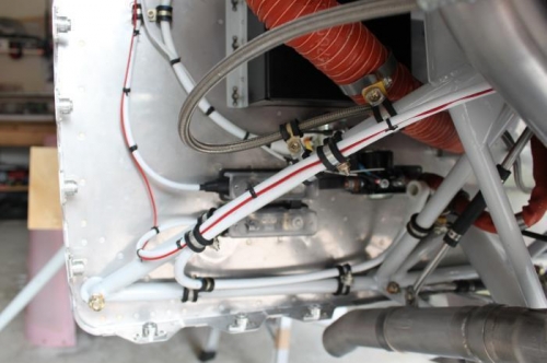 Turns up at the firewall and goes to the through-the-firewall fitting above.