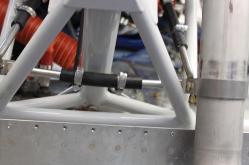 There's no contact here and actually has 1/2 inch free space between gear leg and hose.