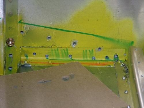 Inside opposite the strut fitting.