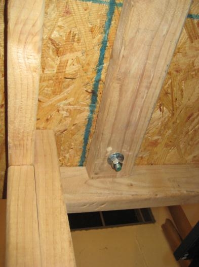 The hole and rod coming through the bottom of the table and the added 2x4.