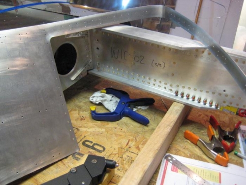 The wing walk/doubler on its side, with the leading edge bend & all pilot holes drilled.
