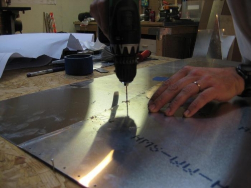 2 nails in work table at each end of metal, ensures alignment between 2 skins, and prevents movement.