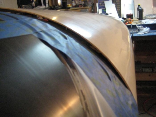 Upper cowl. It is SUPPOSED  to be sitting flush with the blue tape.