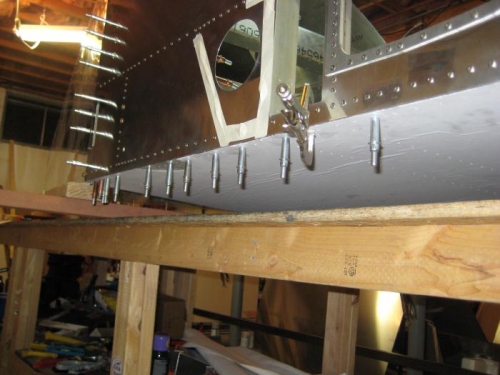 Aft fuselage elevated so forward fuselage bottom skin can be applied.