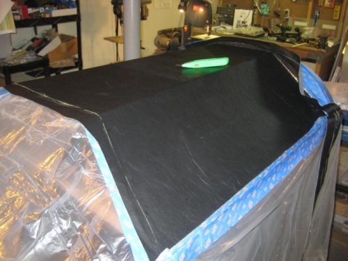 Plastic draped and taped over entire front of fuselage. Beginning fabric cuts.