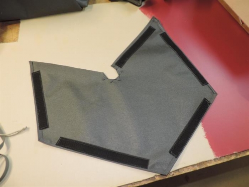 Inside, with velcro to attach to the seat pan.