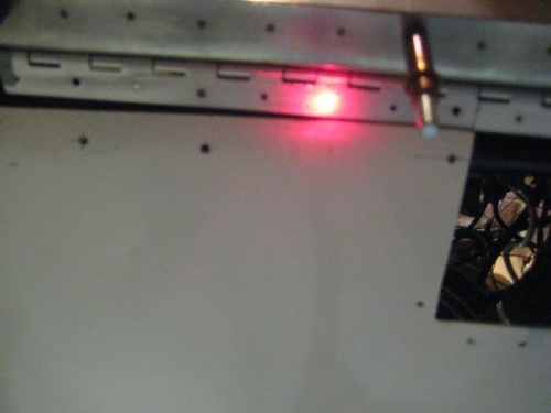 Laser light centered on a pilot hole in the hinge.