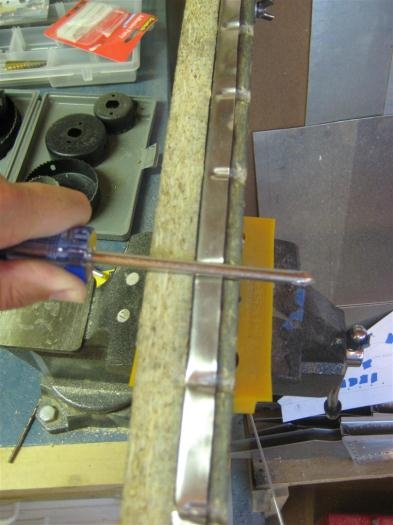 After bending over the flanges, I bang the side of a scredriver with the hammer .