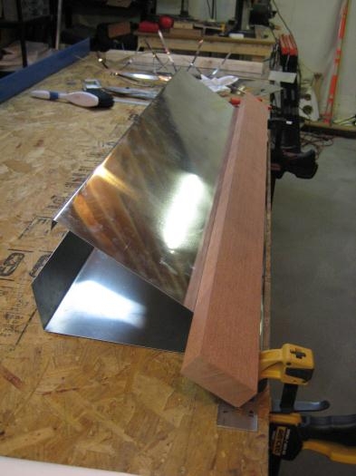 Using a 2x4 to push down on the skin to make the bend more acute.