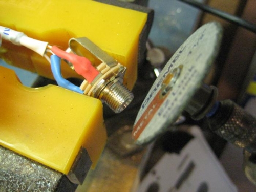 Using cut-off wheel to remove the centering tab on the jacks