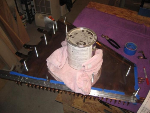 Heavy can of paint, on a towel, to weight down the skin