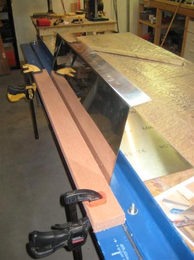 Using a piece of lumber to bend the skin a little further.