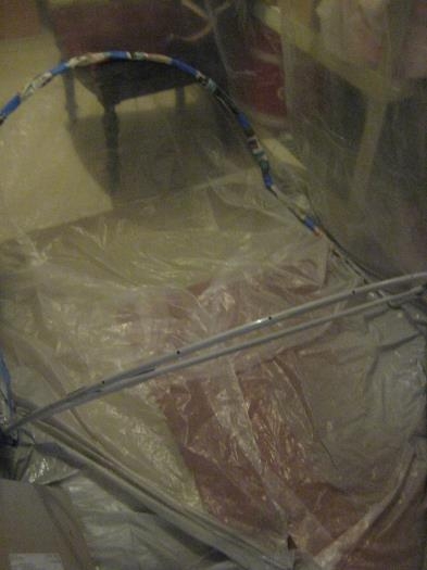 Forward frame covered with newspaper and tape. Foreground is painted rear frame.