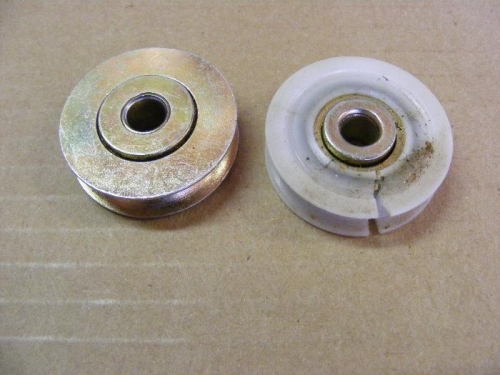 An original nylon pully along side a new steel one.