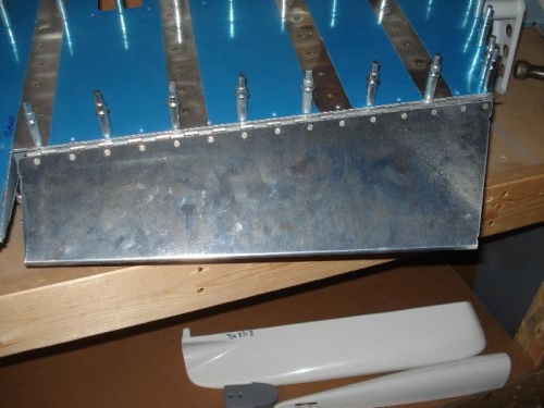 Tab and hinge riveted in place