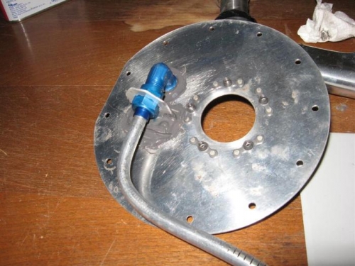 The cover plate with the fitting torqued, locked, & sealed in place.