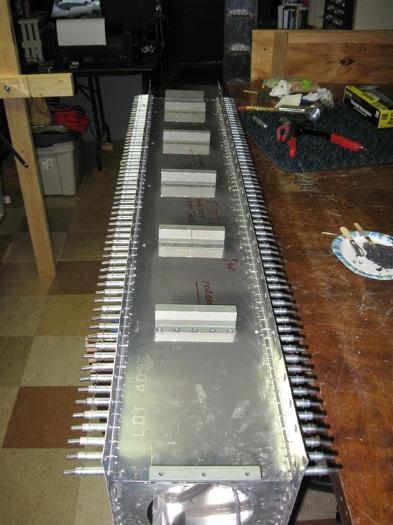 The baffle with the supports riveted in place, and the skin clecoed at each hole.