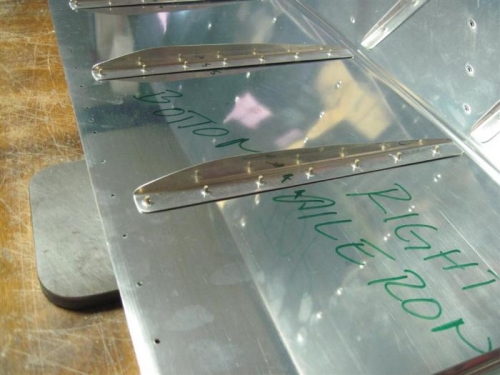 Stiffeners ready to back rivet on the plate peeking out from under the skin