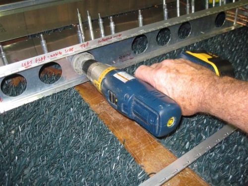 Smoothing the lightening holes in the spar web with the Scotchbrite wheel.