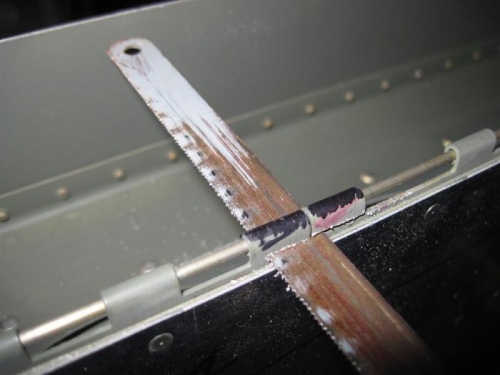 Removing the hinge loops to allow the hinge pins to be inserted from the center.