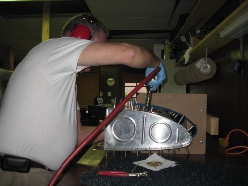 Riveting the top skin of the right tank.