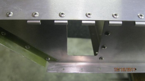 Aileron hinge halk riveted to top skin and aft spar.