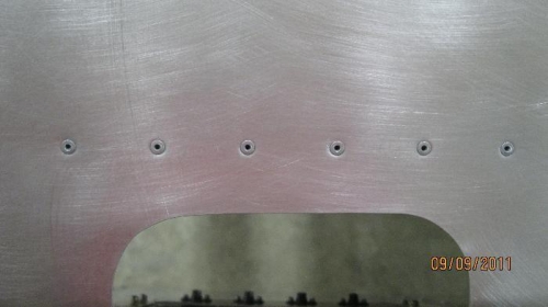 Top skin showing 6 flush rivets holding the lens mounting bracket.